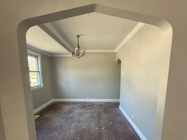 a view of empty room with window and wooden floor