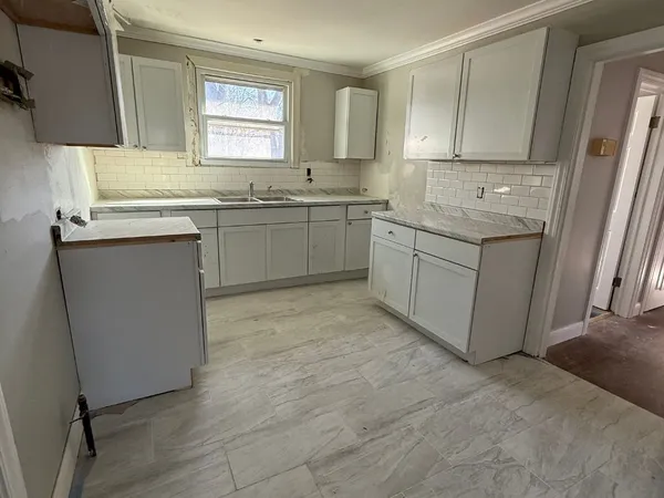 a kitchen with a sink cabinets appliances and a window