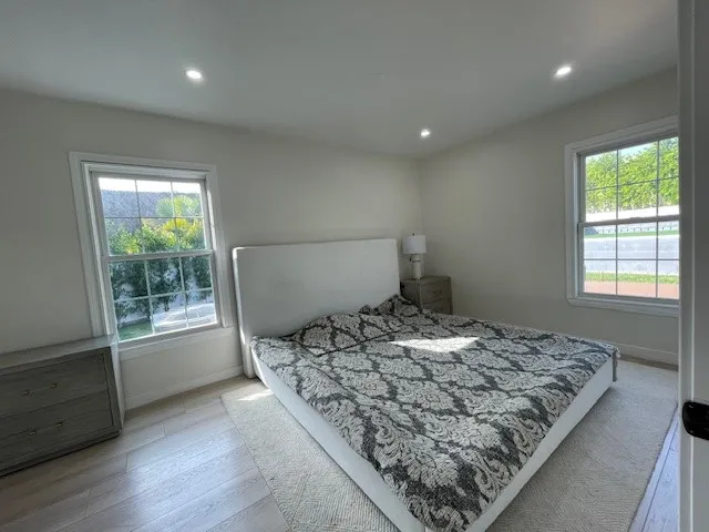 a bed sitting in a bedroom next to a window
