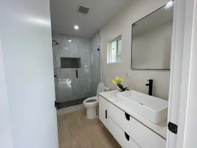 a bathroom with a sink a toilet and mirror