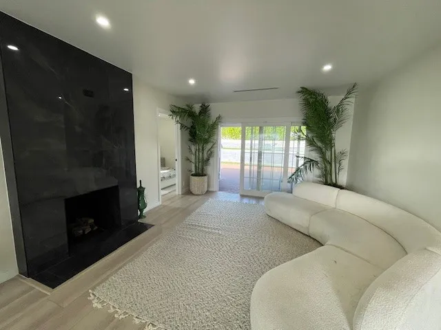 a living room with furniture a fireplace and a floor to ceiling window
