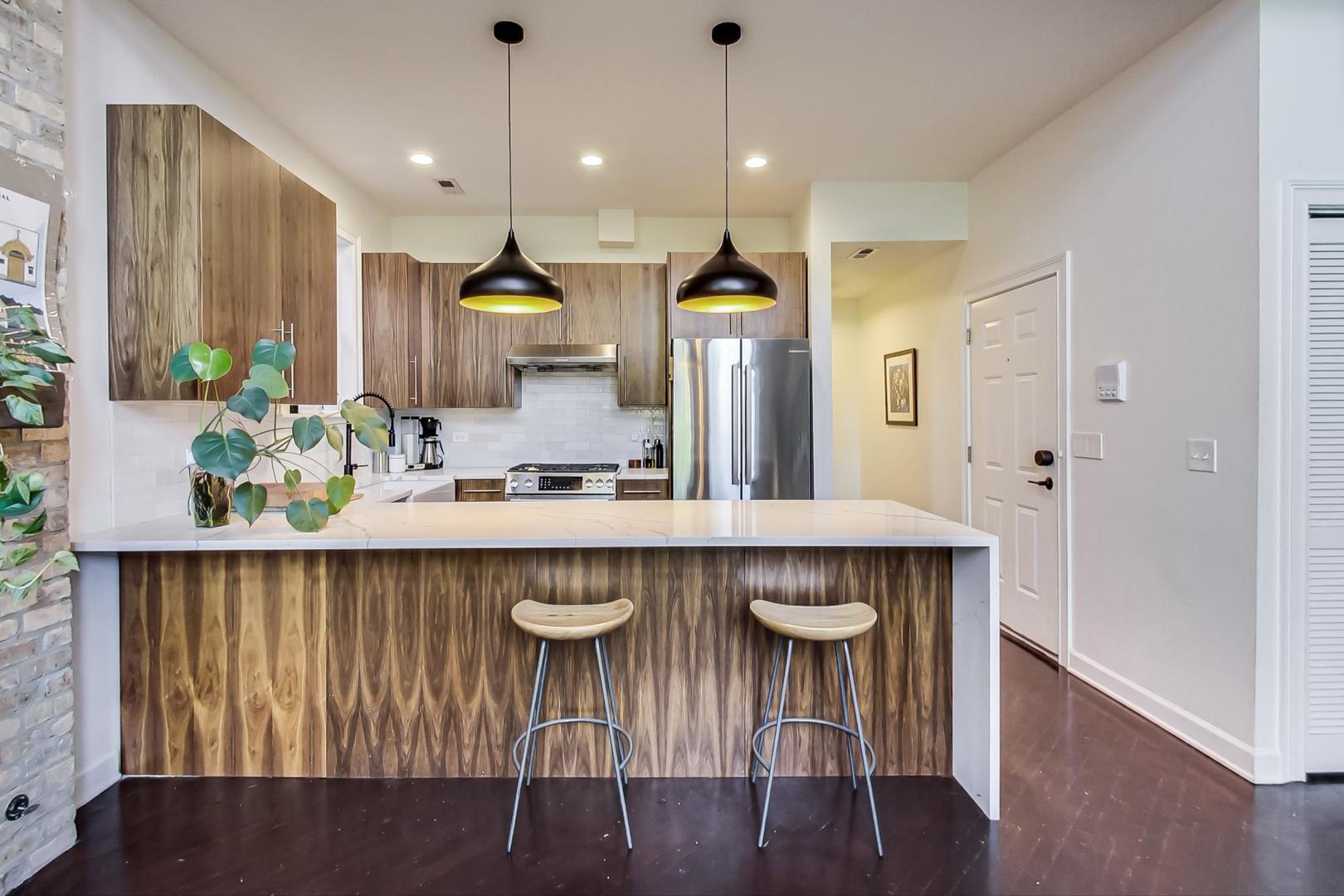 2128 West Walton Street, Unit 3W Chicago, IL 60622 - Photo 5 of 25 a kitchen with a table chairs refrigerator and wooden floor
