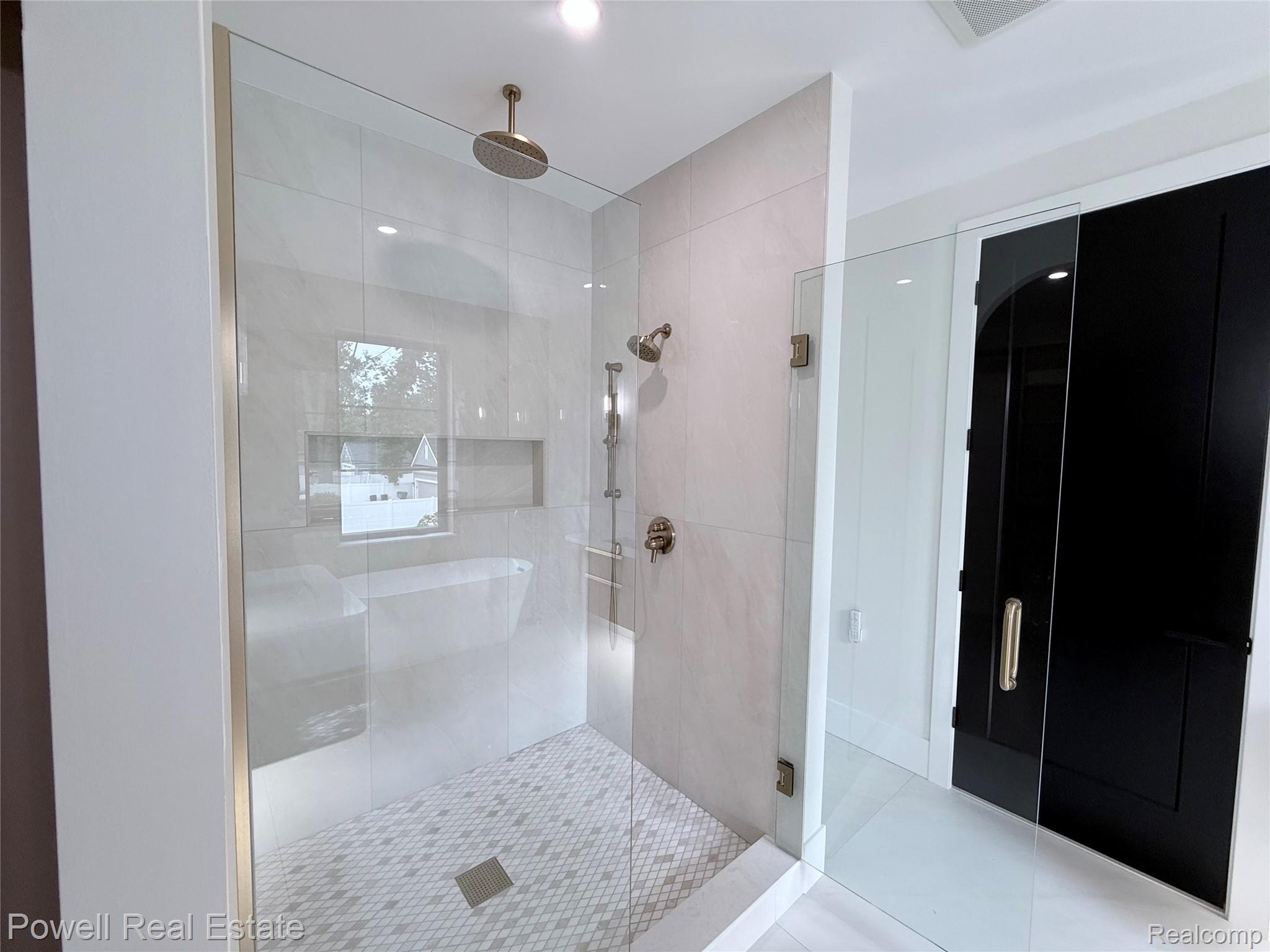 1998 Hazel Street Birmingham, MI 48009 - Photo 16 of 22 Glass-enclosed shower featuring a rain shower head, hand-held shower, tiled walls, and a patterned tile floor
