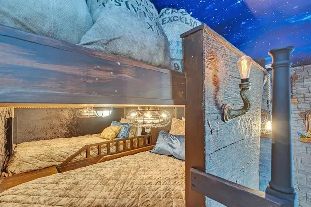 a view of a hallway with wooden floor and a bathroom