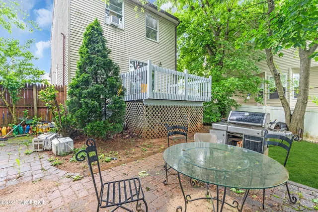 a backyard of a house with barbeque oven table and chairs