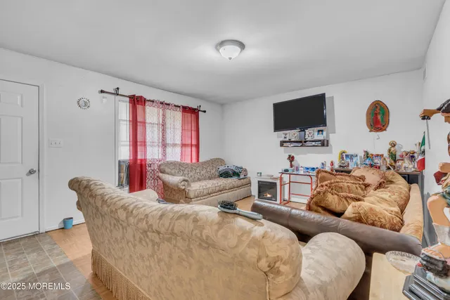 a living room with furniture a flat screen tv and a window