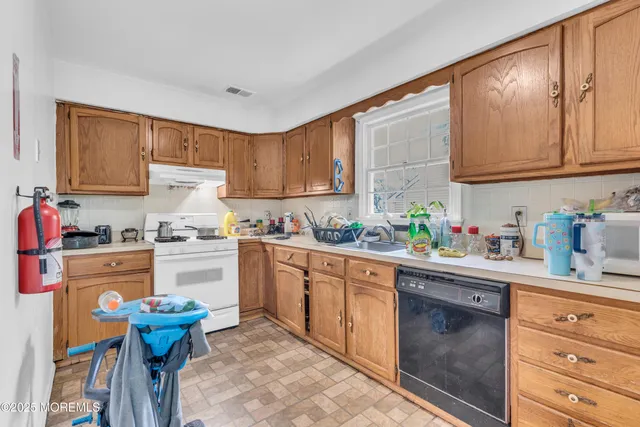 a kitchen with granite countertop a sink stainless steel appliances and cabinets