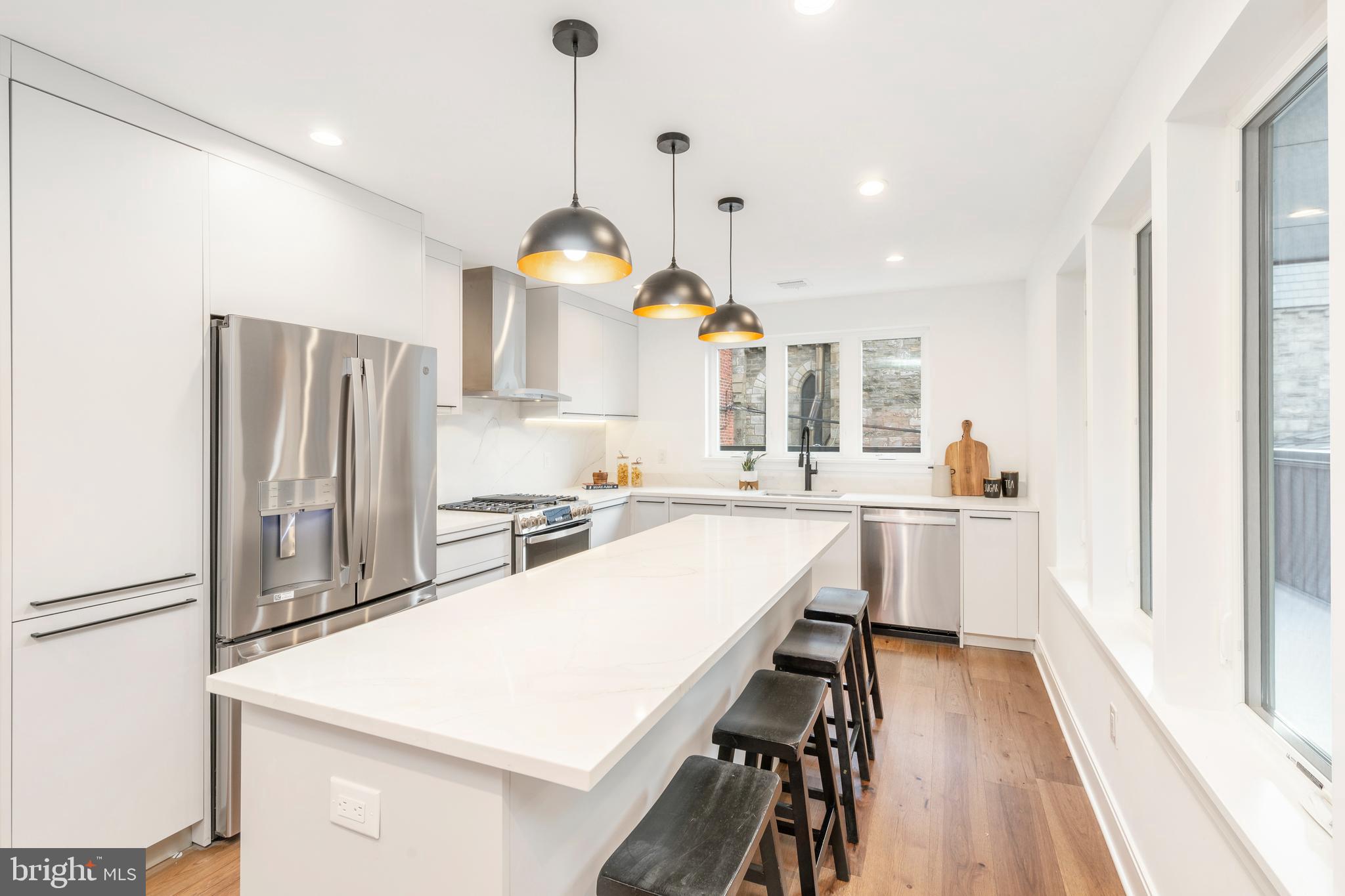 310 Reed Street Philadelphia, PA 19147 - Photo 3 of 45 a kitchen with a table chairs refrigerator and microwave
