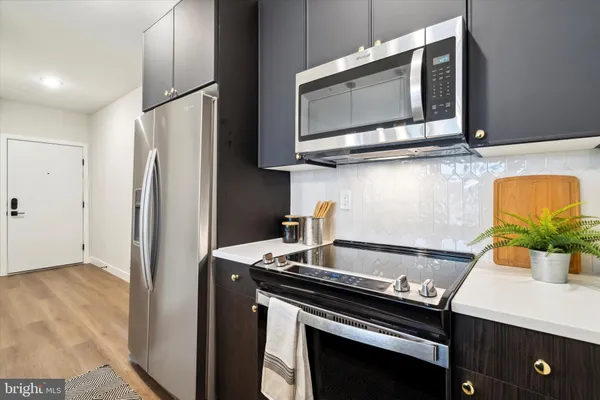 a kitchen with stainless steel appliances granite countertop a refrigerator and a stove top oven