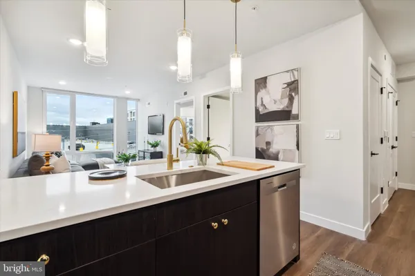 a kitchen with stainless steel appliances kitchen island a sink and wooden floor