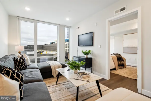 a living room with furniture a flat screen tv and a large window