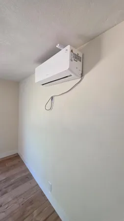 a room with a white wall and wooden floor