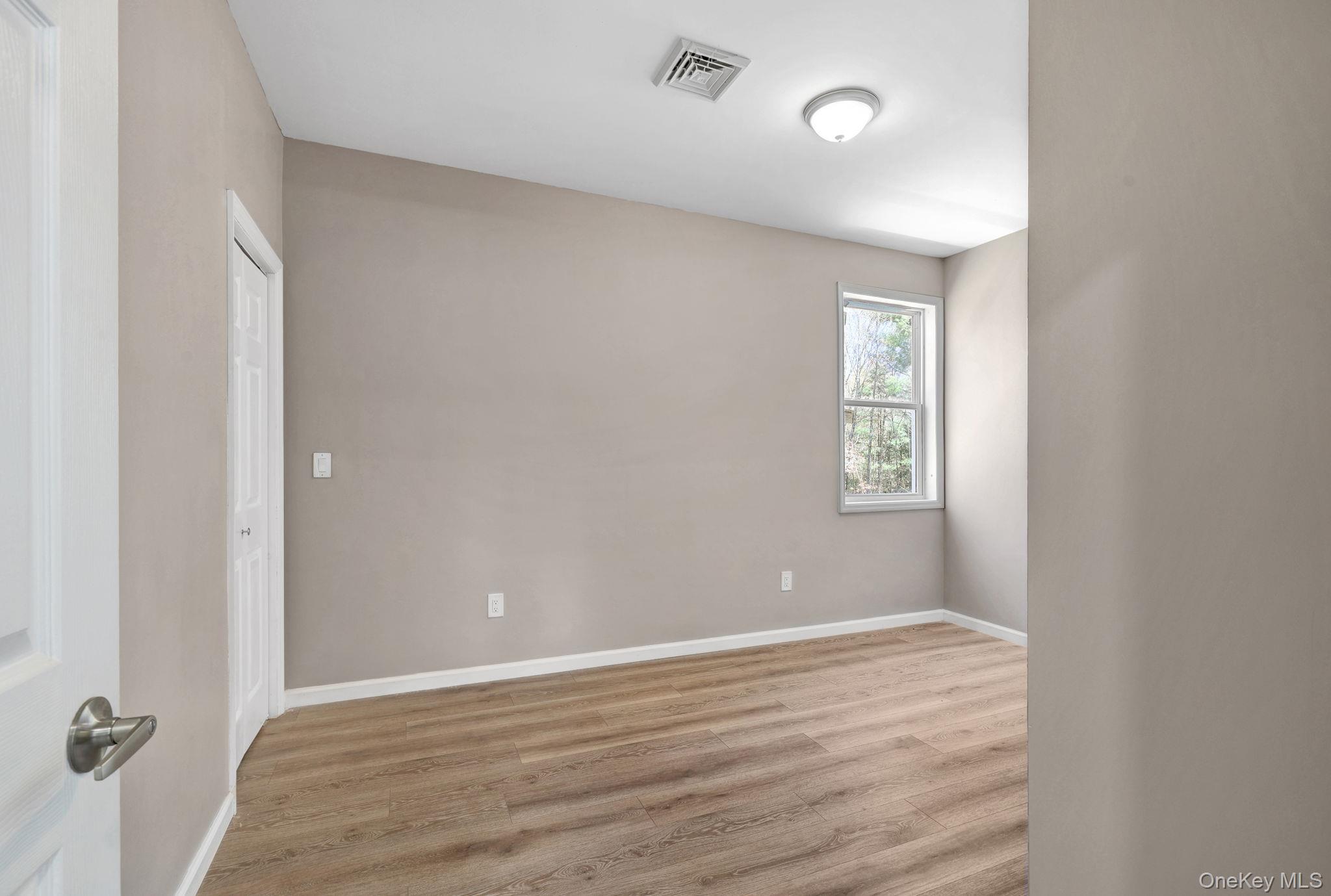 57 Haddock Road Monticello, NY 12701 - Photo 36 of 42 an empty room with wooden floor and windows