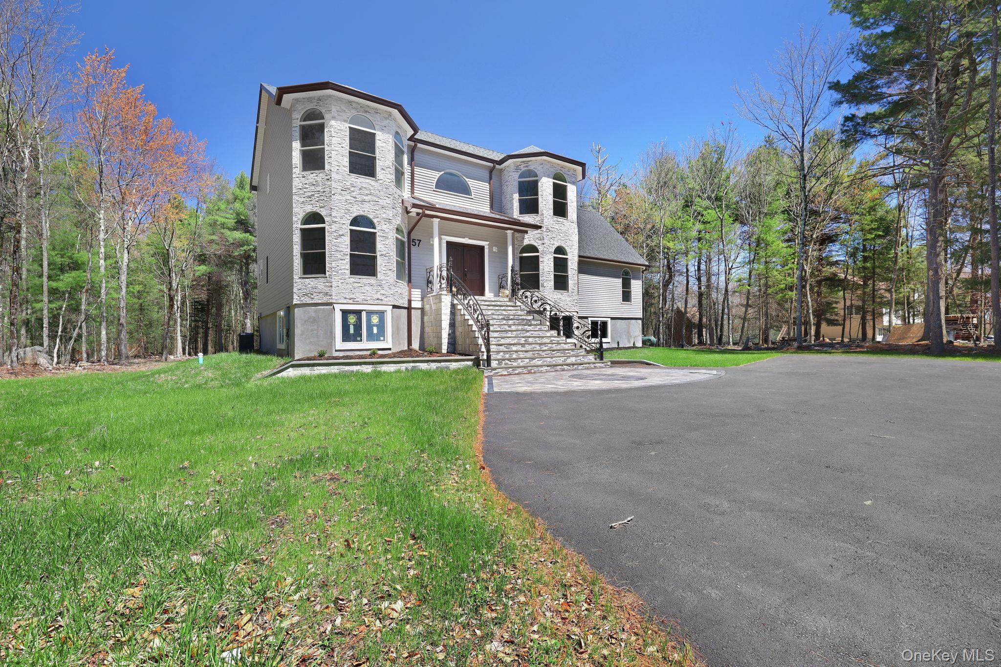 57 Haddock Road Monticello, NY 12701 - Photo 5 of 42 a front view of a house with a yard and trees