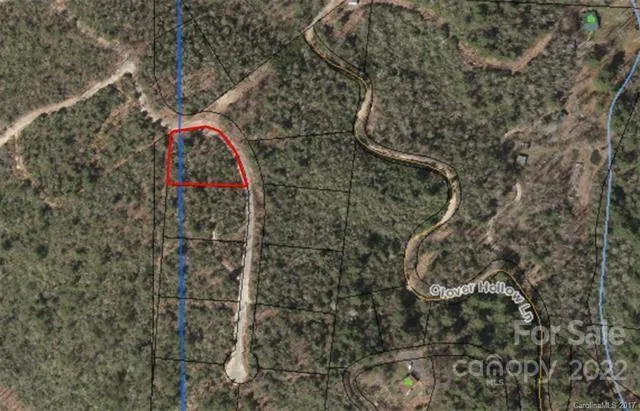 a view of a lush green field with mountains in the background