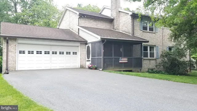 a view of an house with backyard and a tree