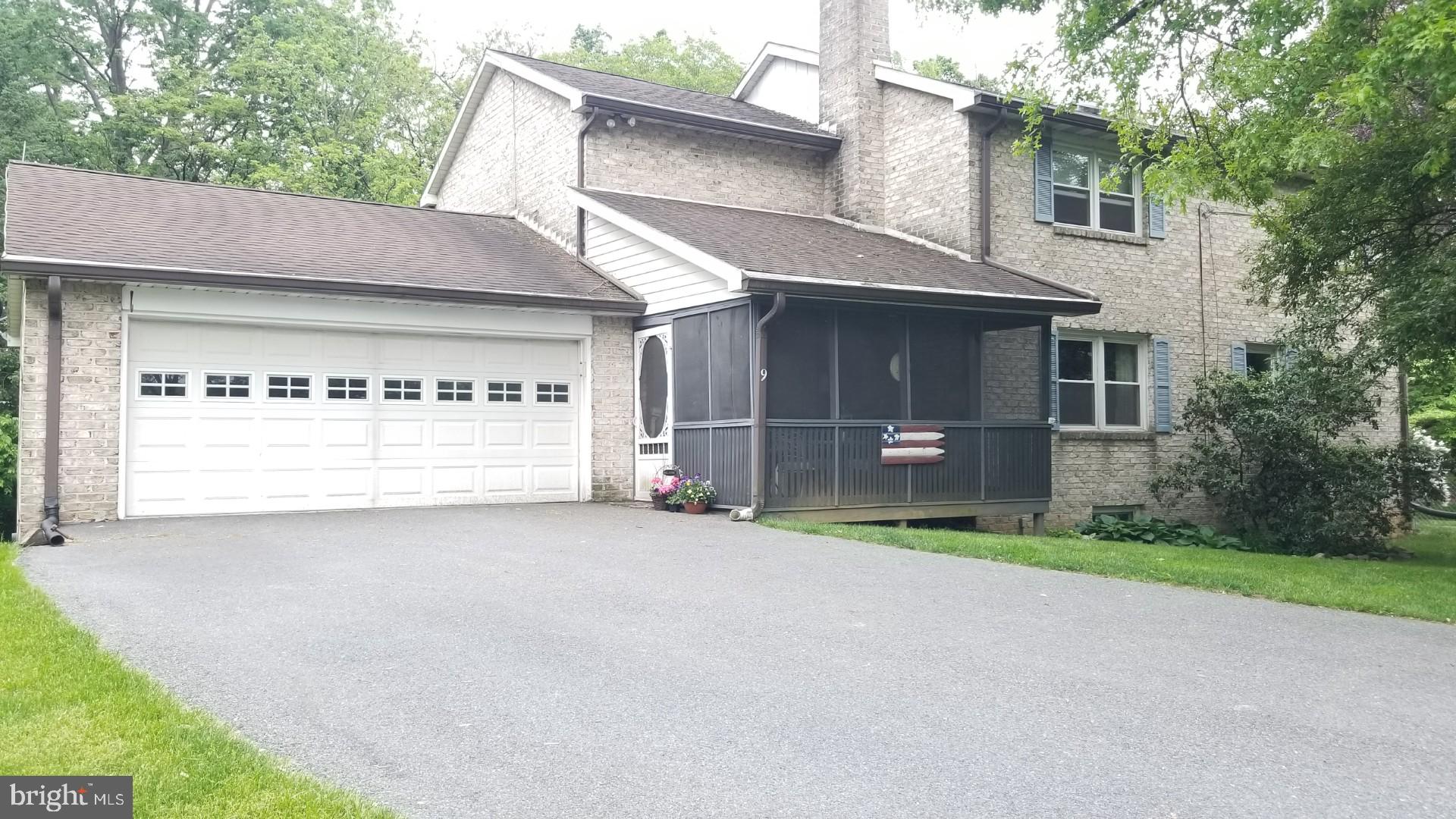 a view of an house with backyard and a tree