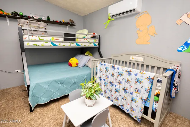 a bedroom with a bed and a lamp on dresser