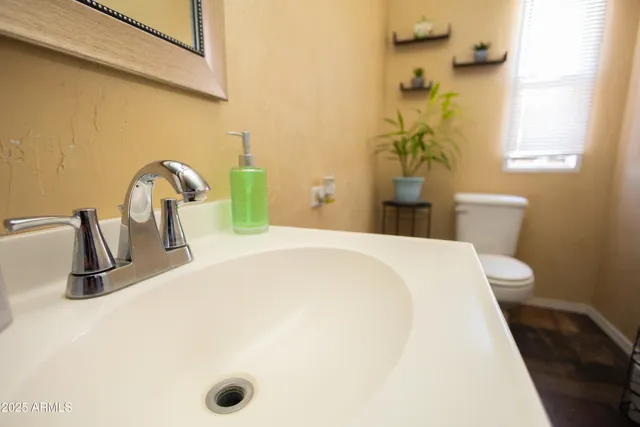 a spacious bathroom with a toilet sink and mirror
