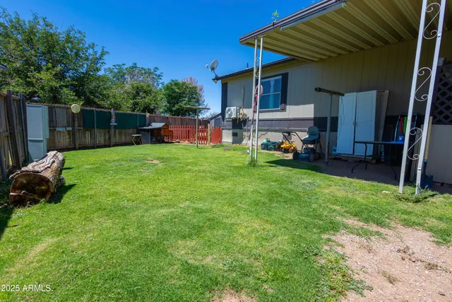 a view of a chair and table in backyard of the house