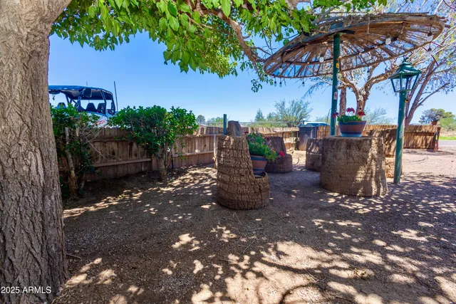 a view of a patio with table and chairs potted plants and large tree