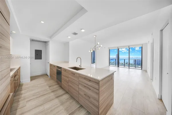 a large white kitchen with a large window