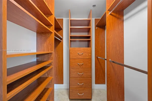 a view of walk in closet with empty racks