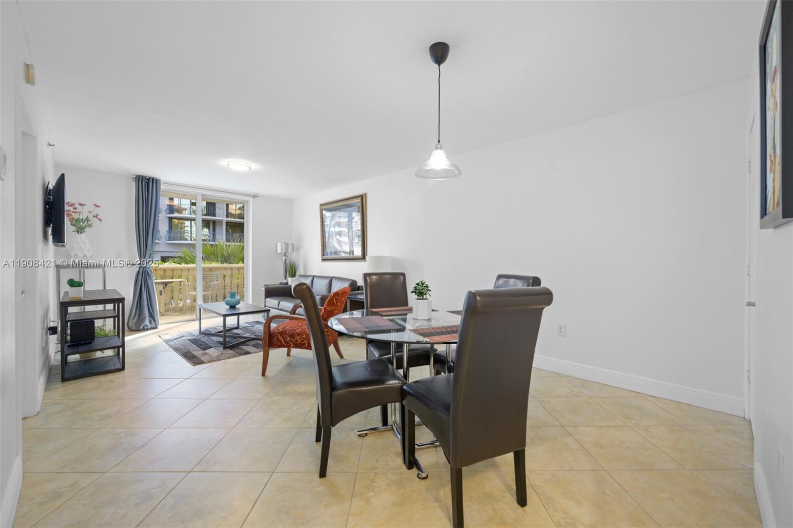 8888 Collins Avenue, Unit 105 Surfside, FL 33154 - Photo 3 of 29 a dining room with furniture a fireplace and a chandelier