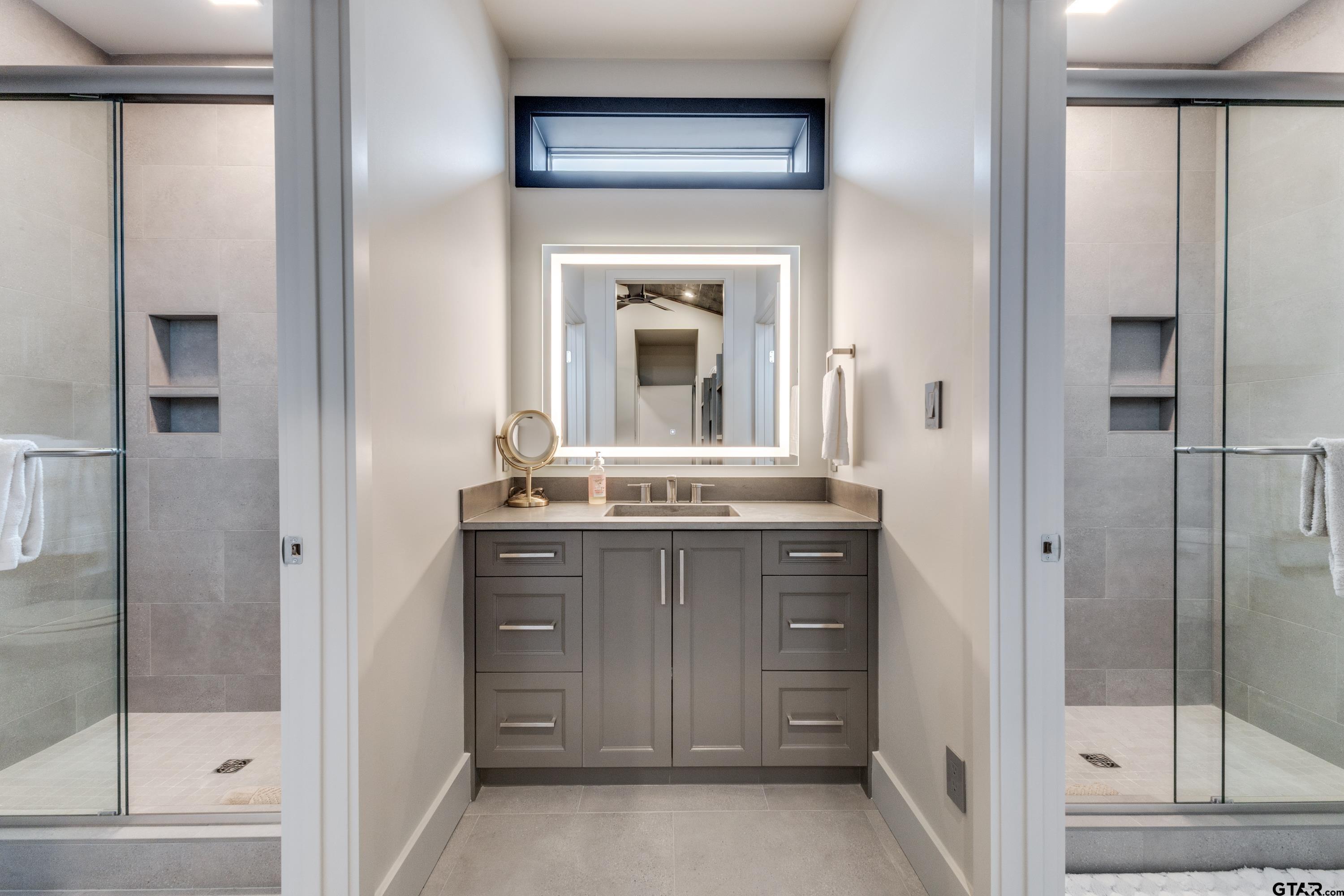 900 West Fm Saltillo, TX 75478 - Photo 17 of 36 a bathroom with a granite countertop sink a mirror and shower
