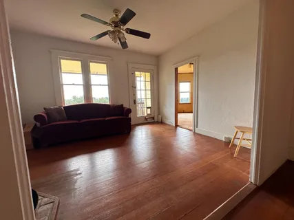 a view of a livingroom with furniture wooden floor and windows