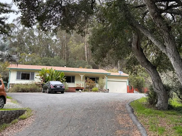 a view of house with car parked beside of it