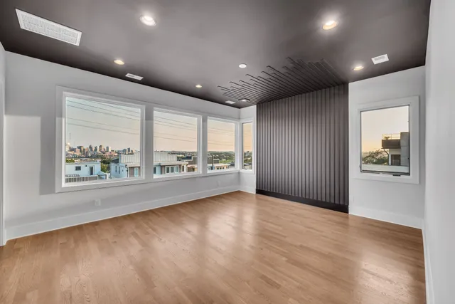 a view of an empty room with a chandelier fan