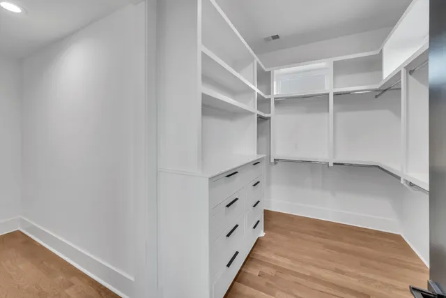 an empty room with wooden floor and window