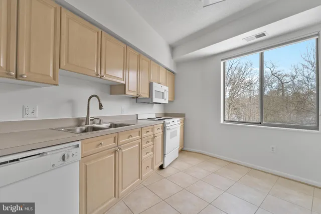 a kitchen with white cabinets and white appliances