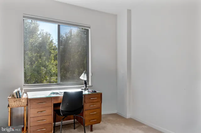 a view of a workspace with furniture and a window