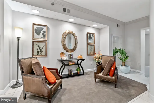 a living room with furniture a clock and a potted plant
