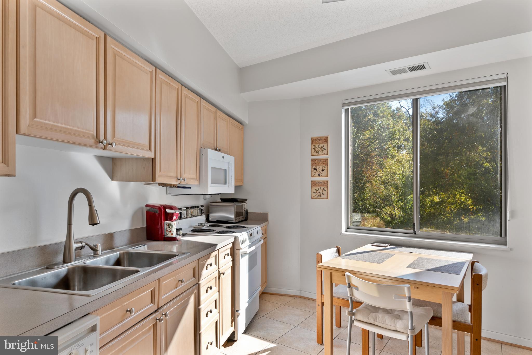 2900 North Leisure World Boulevard, Unit 301 Silver Spring, MD 20906 - Photo 6 of 30 a kitchen with stainless steel appliances granite countertop a sink a stove and a refrigerator