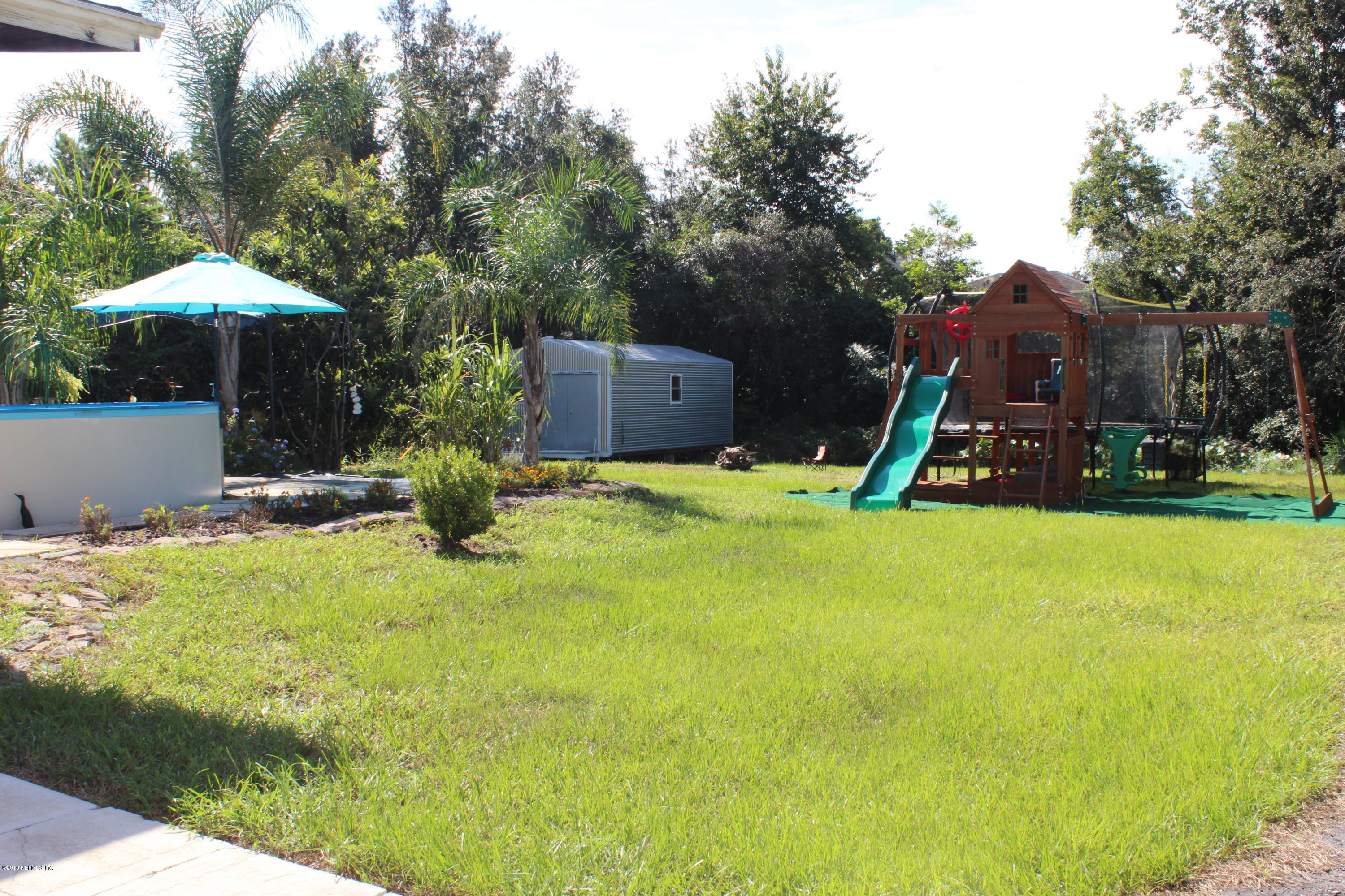 570 Ruba Road St. Augustine, FL 32086 - Photo 22 of 27 a swimming pool with a bench and trees