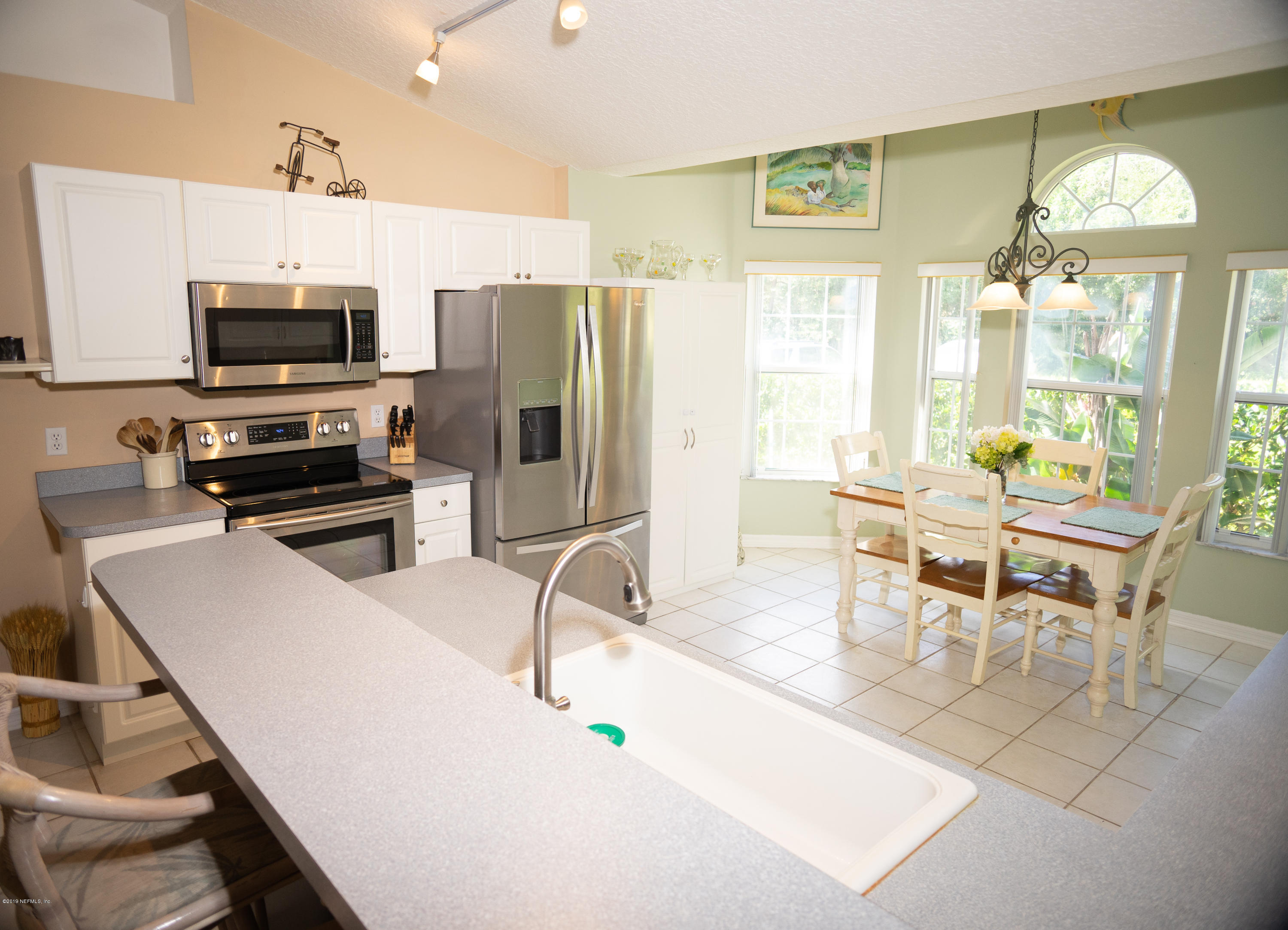 570 Ruba Road St. Augustine, FL 32086 - Photo 6 of 27 a kitchen with stainless steel appliances a table and chairs in it