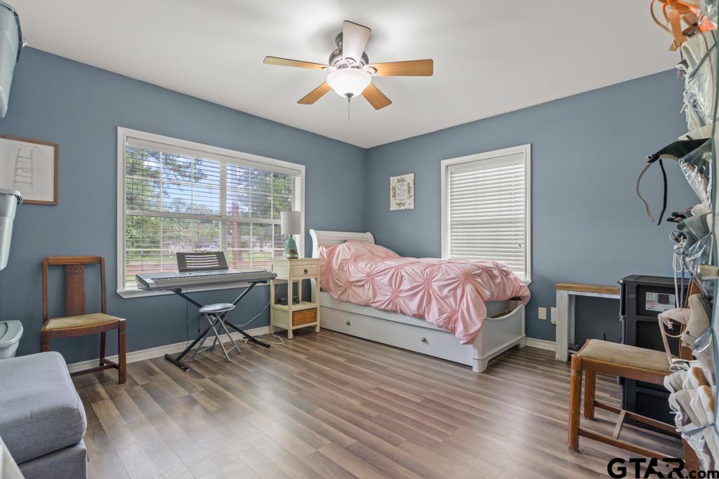 2144 State Highway 155 Gilmer, TX 75644 - Photo 12 of 26 a bedroom with a bed a desk and chair with a large windows