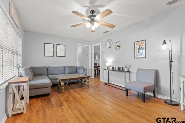 a living room with furniture and a wooden floor