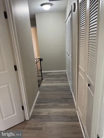a view of a hallway with wooden floor and staircase