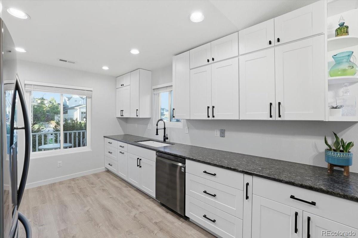 12209 Crystal Downs Road Peyton, CO 80831 - Photo 3 of 37 a kitchen with granite countertop white cabinets and white appliances