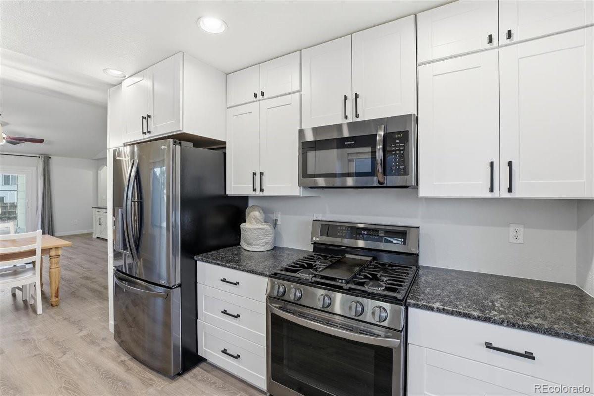 12209 Crystal Downs Road Peyton, CO 80831 - Photo 4 of 37 a kitchen with stainless steel appliances a refrigerator stove and microwave