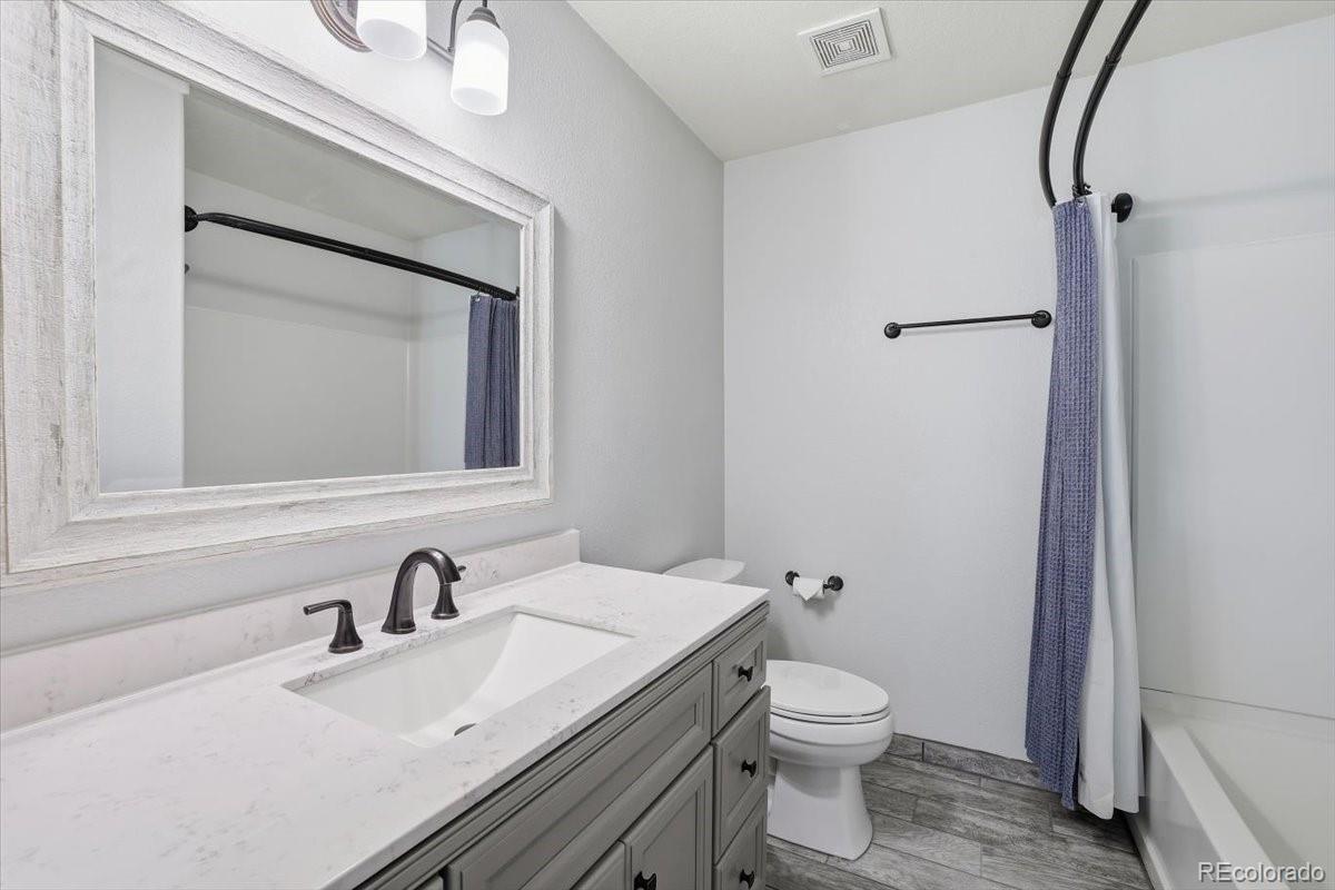 12209 Crystal Downs Road Peyton, CO 80831 - Photo 7 of 37 a bathroom with a toilet a sink and mirror