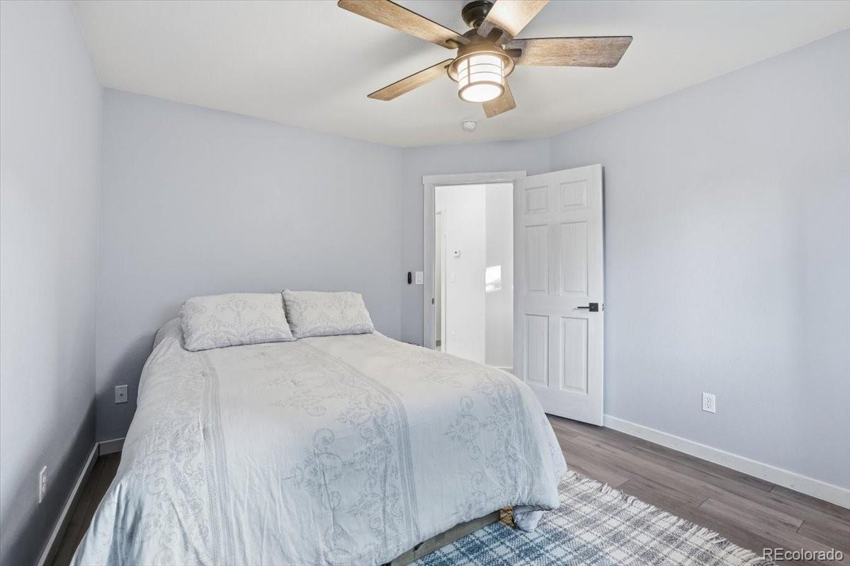 12209 Crystal Downs Road Peyton, CO 80831 - Photo 8 of 37 a bedroom with a large bed and a chandelier