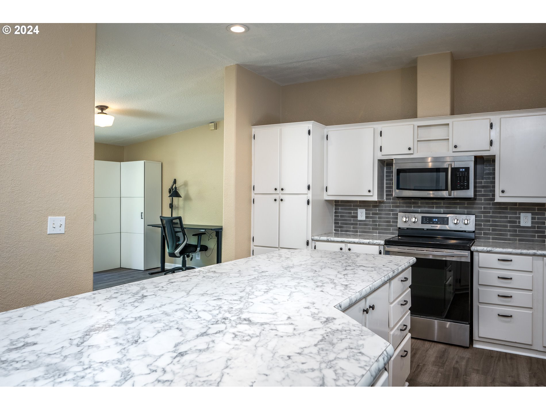 6007 Northeast Lessard Road Camas, WA 98607 - Photo 20 of 48 a kitchen with stainless steel appliances kitchen island granite countertop a stove top oven a sink dishwasher and a refrigerator with wooden floor