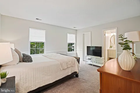a bedroom with a bed a flat screen tv and a fireplace