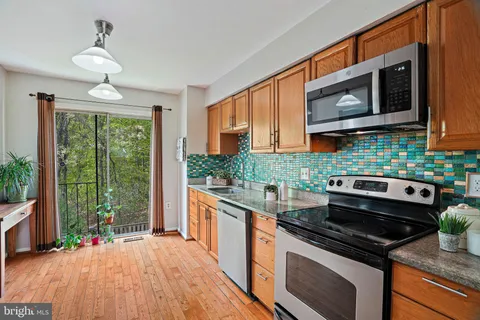 a kitchen with stainless steel appliances granite countertop a stove and a microwave