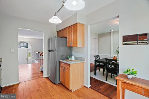 a kitchen view with granite countertop a refrigerator and a stove top oven